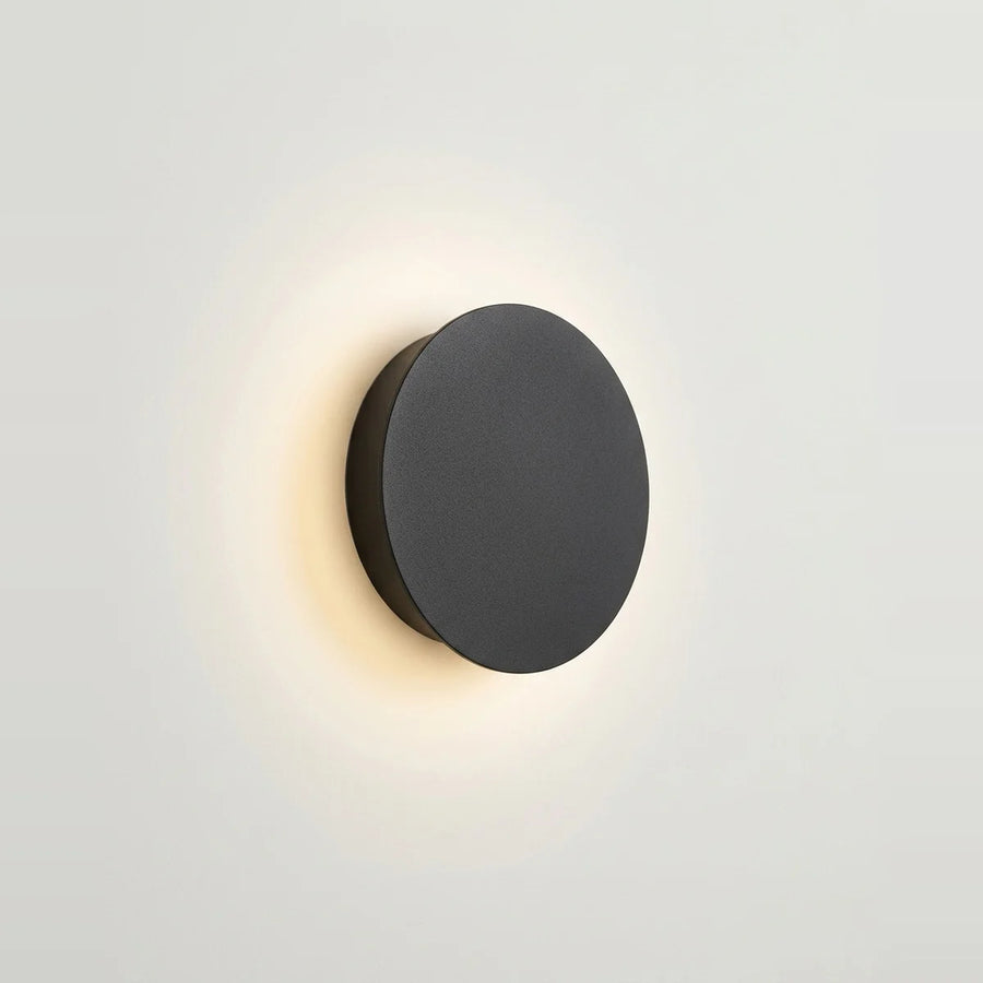 Round Black LED Wall Sconce, 5 in, Halo Backlight – Black, standard switch, on a light background