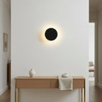 Applique murale ronde LED noire Ø 13 cm, éclairage haut et bas, mise en situation dans un couloir