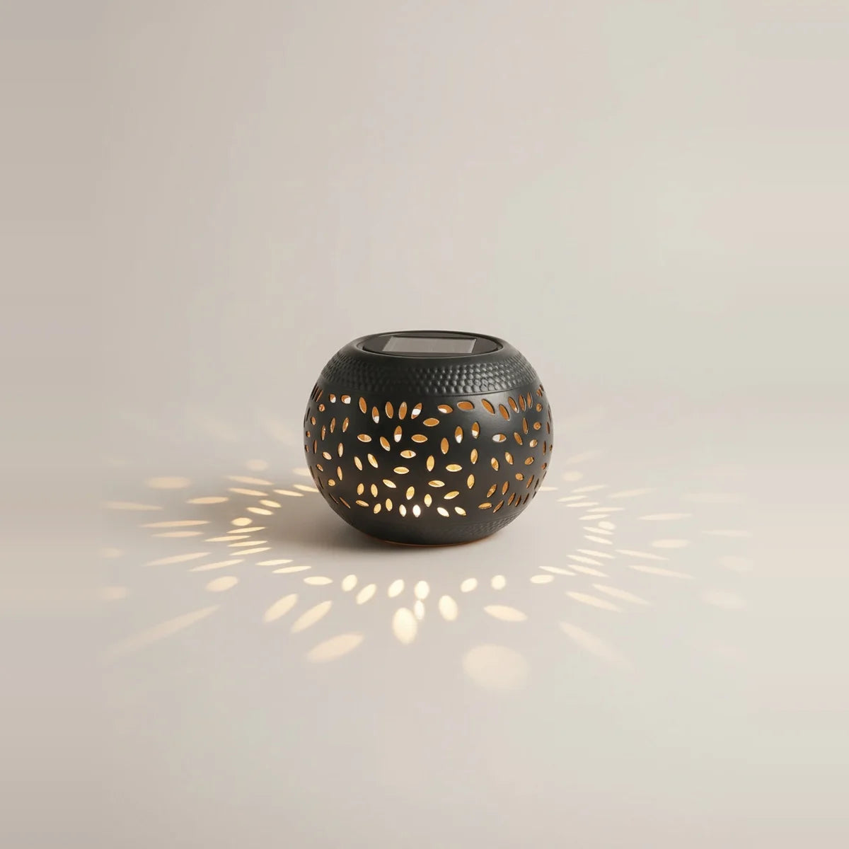 Solar Outdoor Table Lamp, Black Cut-Out Metal Lantern, on a light background